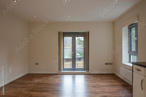 View of an empty living room area in a modern apartment with wooden flooring © ink drop