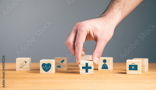 man holding wooden blocks with medical symbol