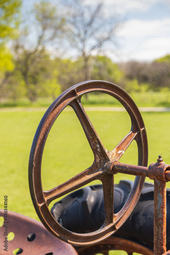 Old rusty tractor seat, wheel, and steering wheel