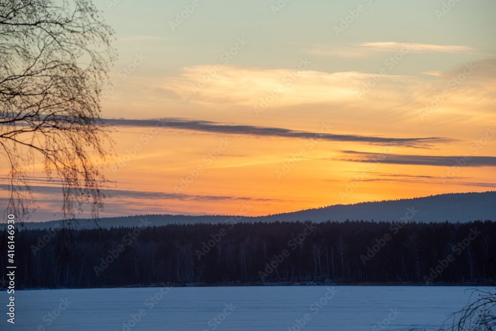 Beautiful scenery of sundown on frosty winter evening in the countryside