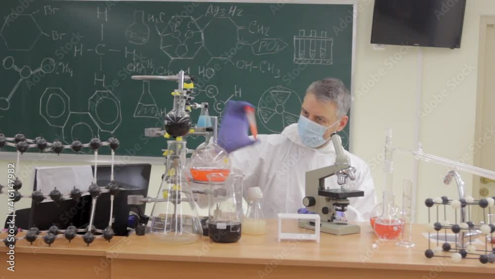 a scientist in a protective suit conducts an experiment in the laboratory a scientist in a protective suit conducts an experiment in the laboratory
