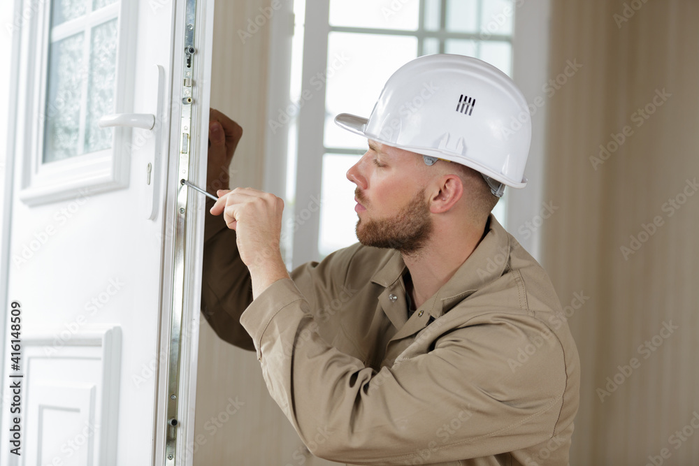 locksmith using screwdriver on door of residential property locksmith using screwdriver on door of residential property