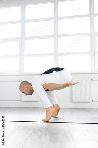 Man Yoga Practice Pose Training Concept, Doing Complex Pose Training, Man Standing On His Tiptoes Keeping Balance. Indoors Alone. Healthy Lifestyle Concept