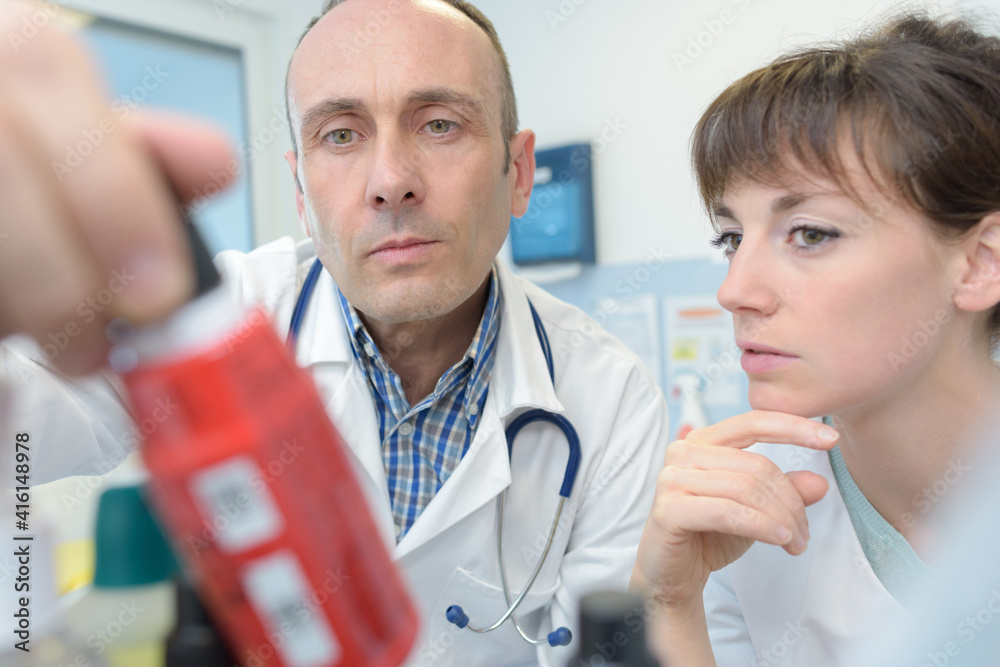 nurse an doctor checking a bottle of medicine nurse an doctor checking a bottle of medicine