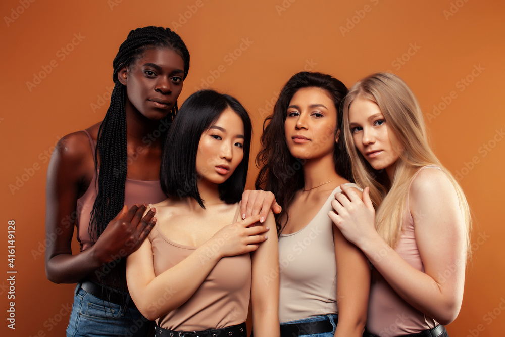 Fototapeta premium young pretty asian, caucasian, afro woman posing cheerful together on brown background, lifestyle diverse nationality people concept