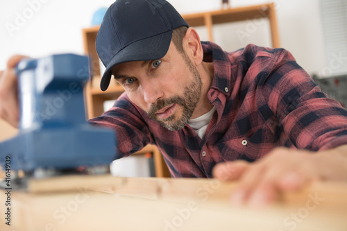 man using an electric sander