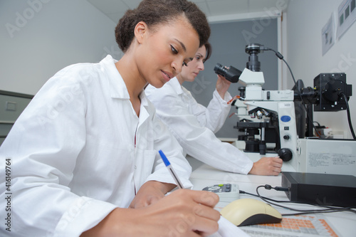 Female laboratory technician making notes photo