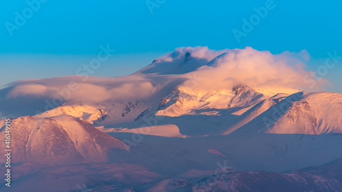 Clouds on a volcanic Erciyes mount in Kayseri. Snowy scarlet mountain. Erciyes is a large stratovolcano, reaching a height of 3,864 m it the highest mountain and most voluminous volcano of Central Ana