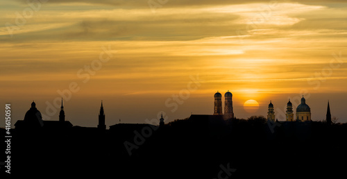 Silhouette Munich Skyline with dramatic orange sunset behind Frauenkirche