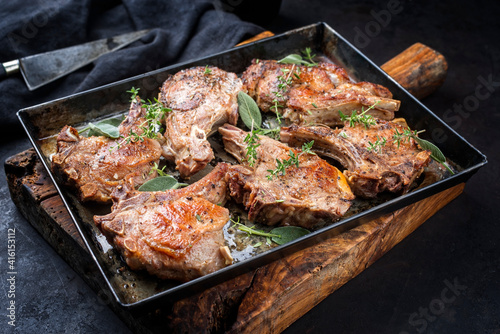 Fotografia Traditional barbecue dry aged veal chops served as close-up in a rustic tray on