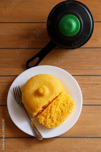 Brazilian Couscous (Cuscuz Brasileiro) and a couscous pan on wooden background, with copy space. Vertical photo. photo