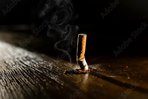 Smoking burning cigarette on a dark background. Stop smoking concept