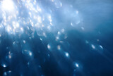 Abstract blue background with underwater scene sunrays and air bubbles in deep sea