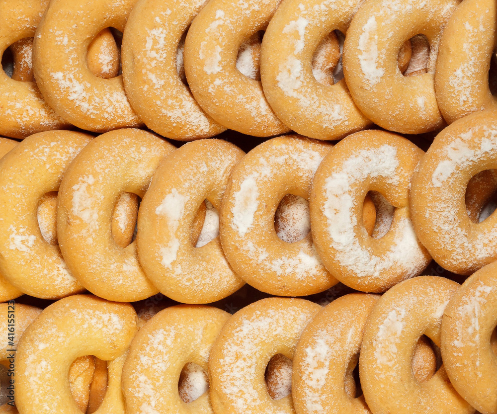 Donuts with powder suger in a row. Background. Top view. Donuts with powder suger in a row. Background. Top view.