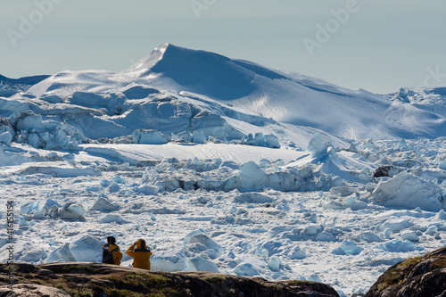 Greenland. Ilulissat. Visitors taking in the expanse of the Icefjord. photo