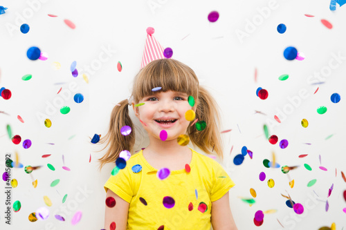 happy child girl with confetti on white background 
