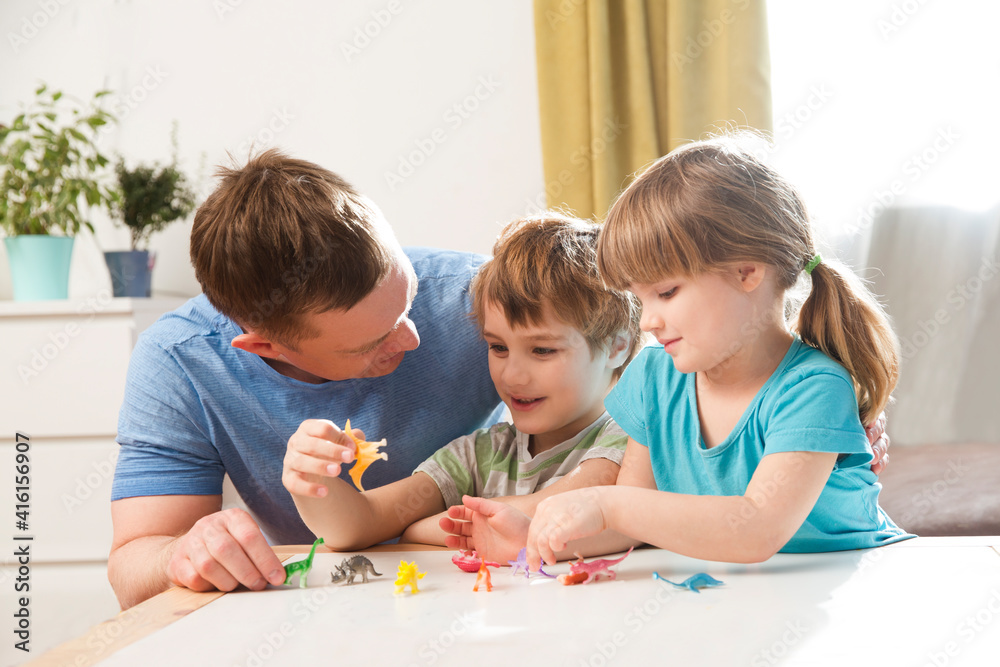 Dad with two kids playing animal figures together at home. Family having fun playing at home. stay home concept Dad with two kids playing animal figures together at home. Family having fun playing at home. stay home concept
