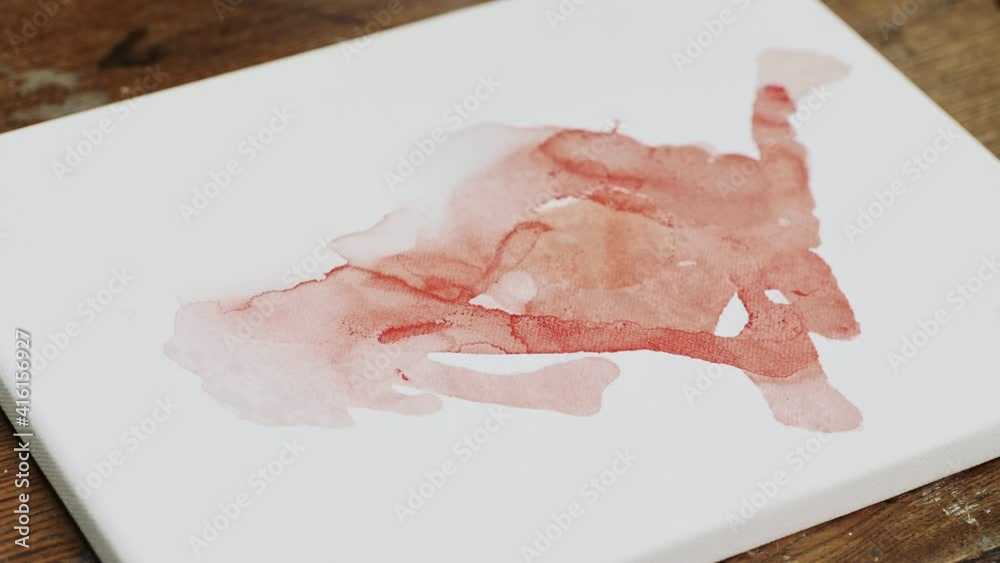 Fluid Art. Abstract colorful painting. Close up of female artist pours water to canvas Fluid Art. Abstract colorful painting. Close up of female artist pours water to canvas
