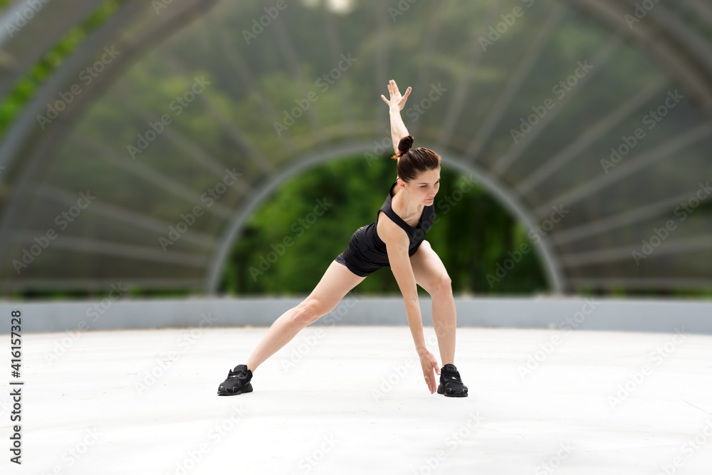 Portrait of fit and sporty young woman doing exercises of stretching, yoga or pilates in the early morning park. Portrait of fit and sporty young woman doing exercises of stretching, yoga or pilates in the early morning park.