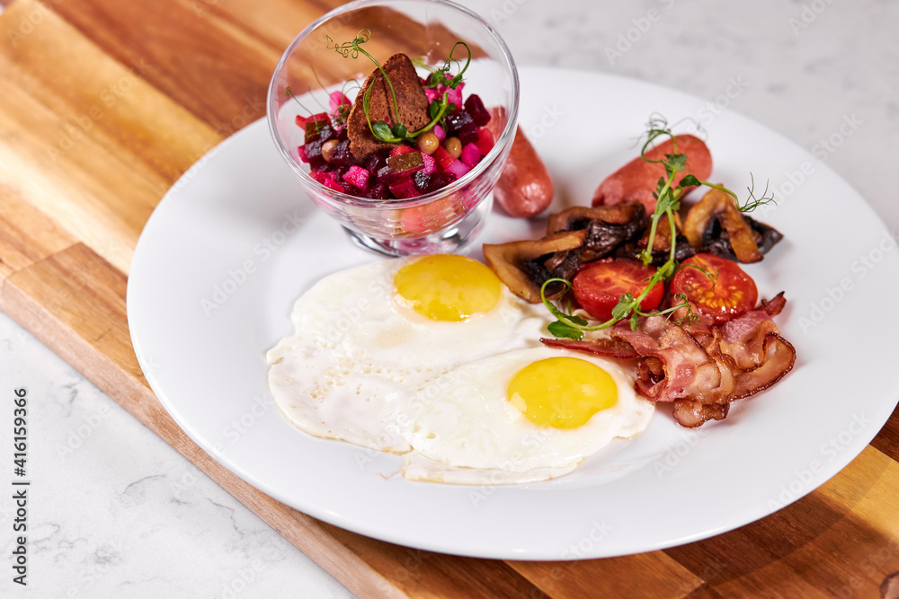 Fried Eggs With Bacon, Tomato and Salad Served At Cafe Table On Wooden Board , English Breakfast. Food, Restaurant concept