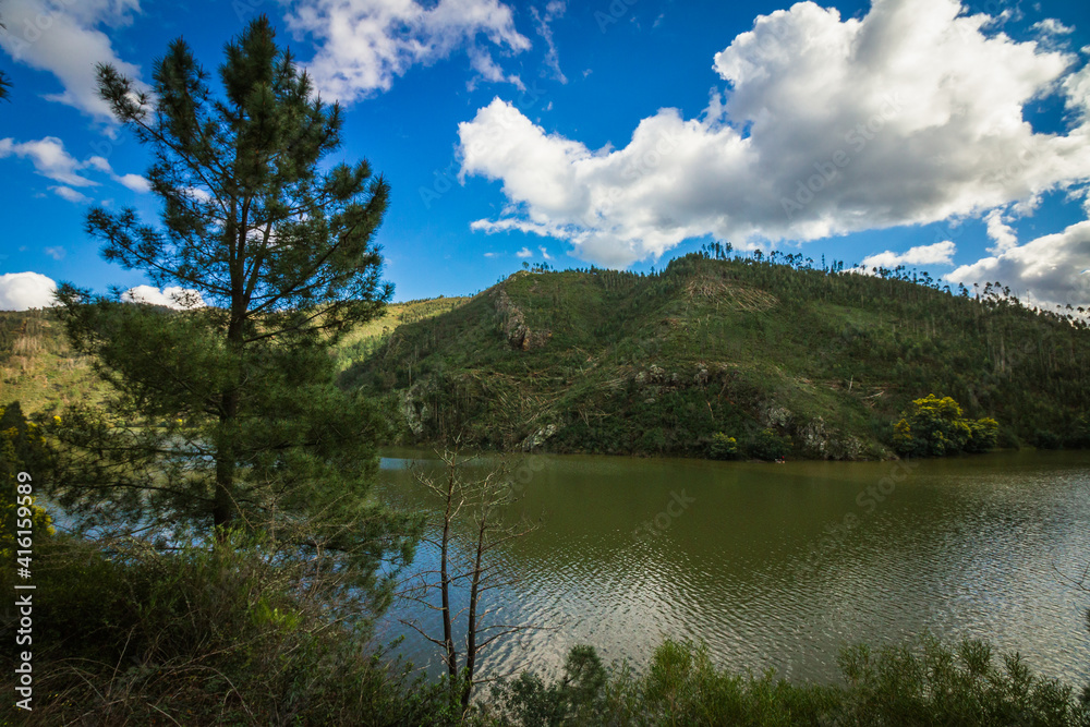 Landscape view of the lake with mountains background and beautiful clouds on the sky. Landscape view of Zezere river in Aldeias de Xisto, Portugal