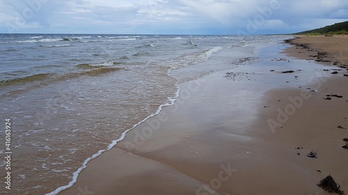 Not a calm autumn sea with a deserted sandy beach and rain clouds