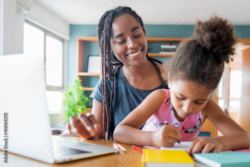 A mother helping her daughter with homeschool.