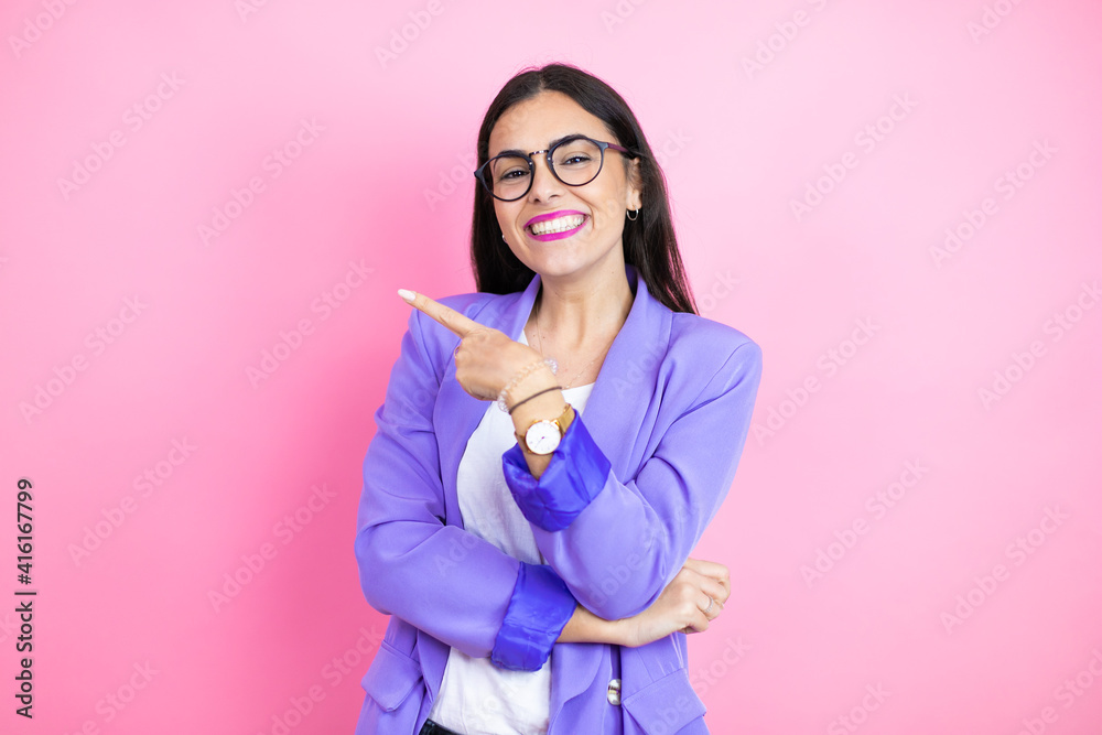 Φωτογραφία Young business woman wearing purple jacket over pink background smiling and poin
