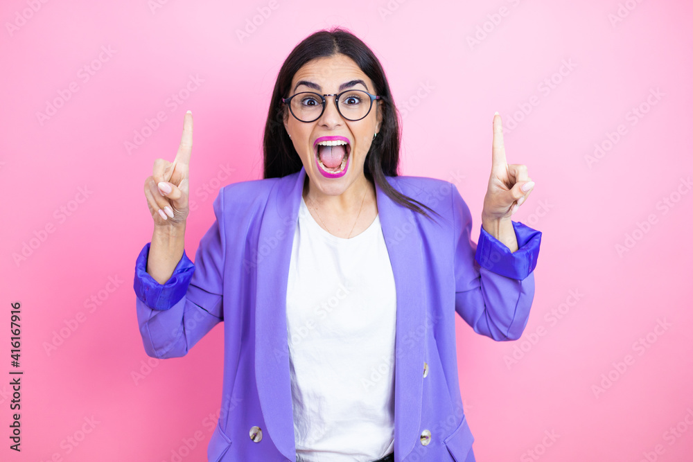 Φωτογραφία Young business woman wearing purple jacket over pink background amazed and surpr