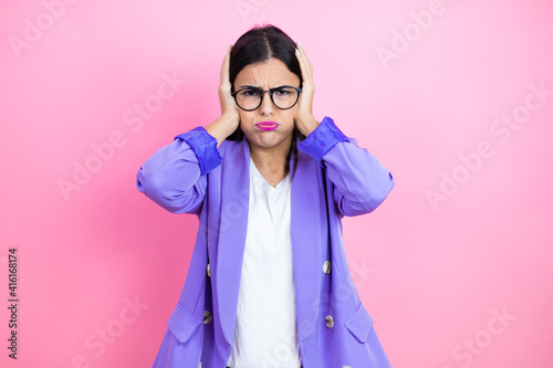 Young business woman wearing purple jacket over pink background thinking looking tired and bored with hands on head © Irene