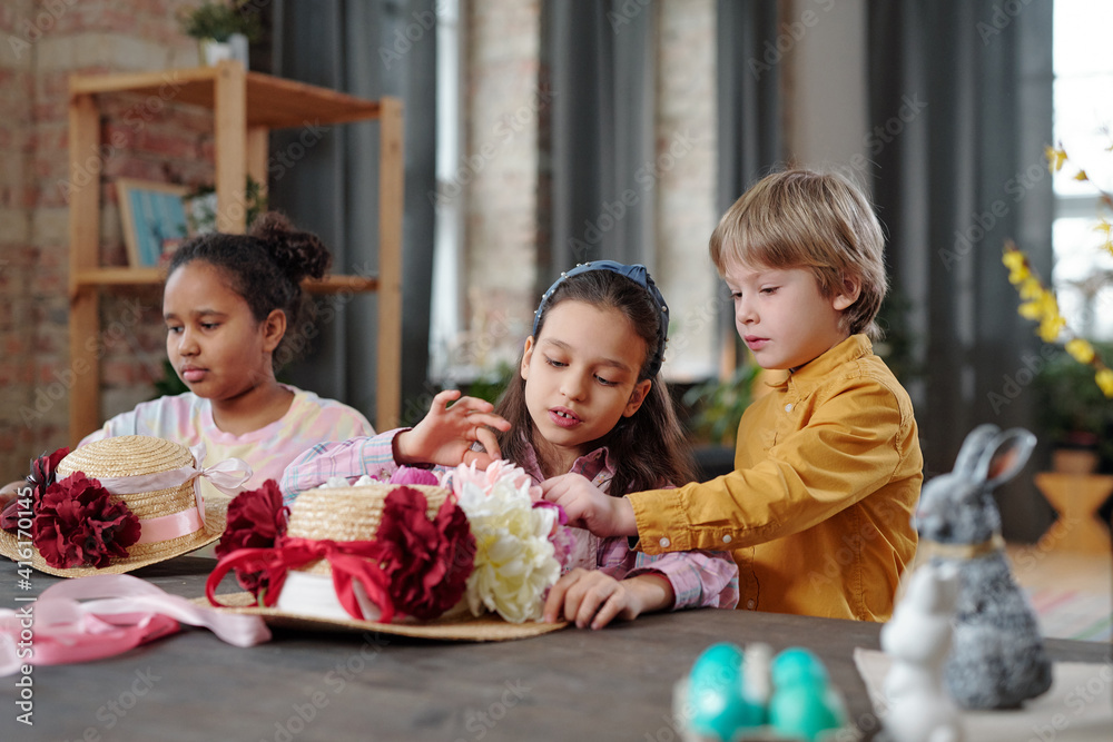 Fototapeta premium Children decorating hats with flowers