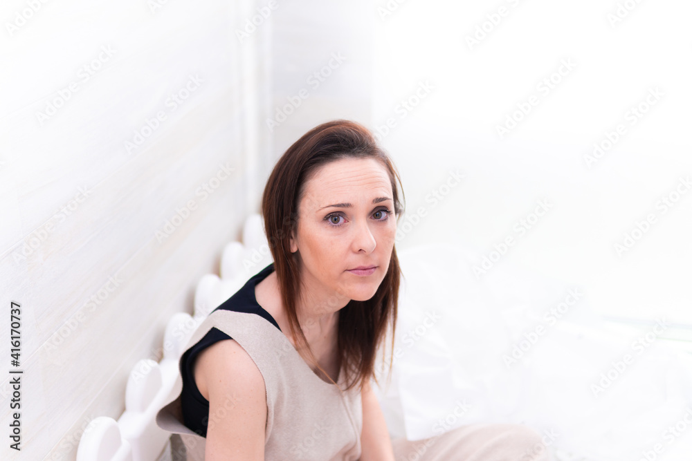 middle-aged young beautiful woman sitting in her babay´s beadroom. motherhood concept middle-aged young beautiful woman sitting in her babay´s beadroom. motherhood concept