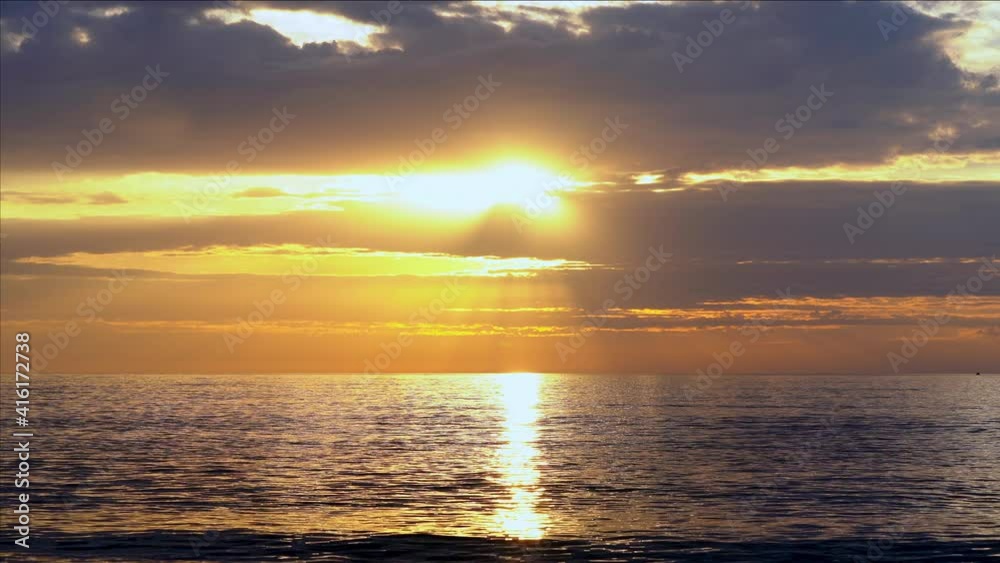 Sunrise over sea surface with bright sun, clouds and orange warm light. Orange sky, yellow sun and amazing cloudscape. Summer sunset seascape with calm and relaxing waves. Ocean beach sunset video 4k. Sunrise over sea surface with bright sun, clouds and orange warm light. Orange sky, yellow sun and amazing cloudscape. Summer sunset seascape with calm and relaxing waves. Ocean beach sunset video 4k.
