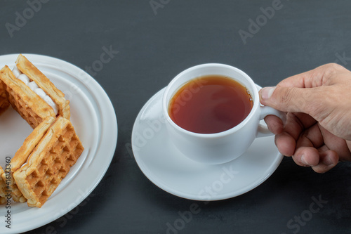 A cup of aroma tea with delicious waffles photo