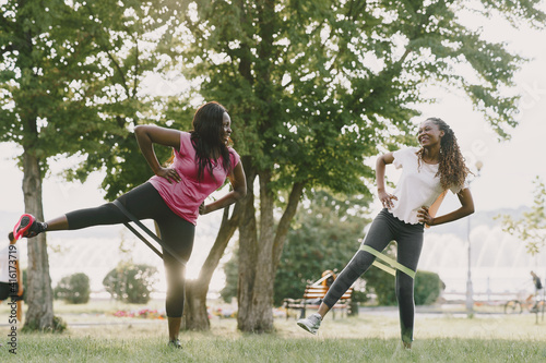 Healthy young african women outdoors in morning park. Friends training.