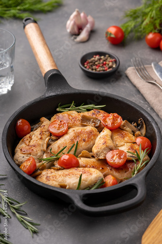 Grilled chicken breast or fillet with tomato on iron pan.