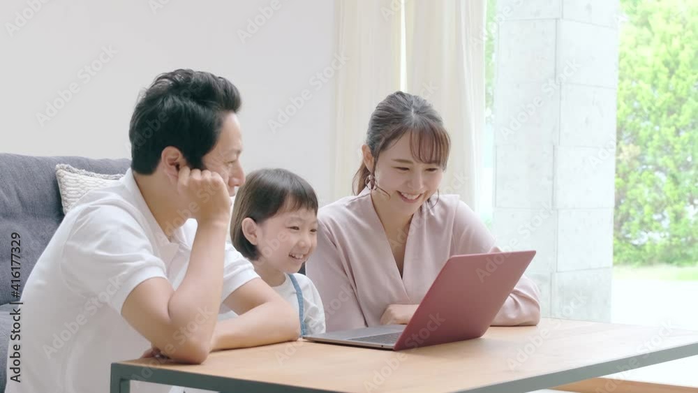 リビングでパソコンを使う家族 リビングでパソコンを使う家族