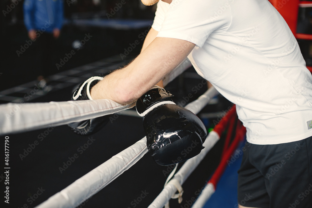 Sporty man boxing. Photo of boxer on a ring. Strength and motivation Sporty man boxing. Photo of boxer on a ring. Strength and motivation