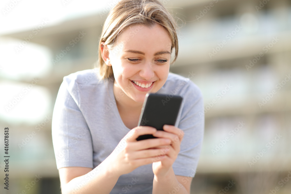 Happy single teen using smart phone in the street Happy single teen using smart phone in the street