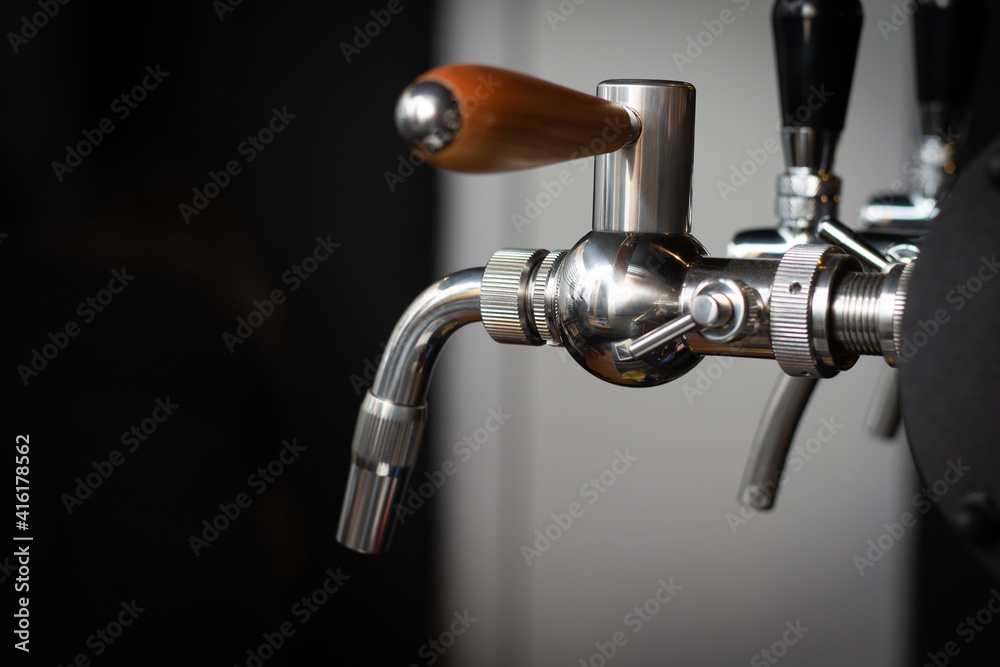 Partially blurred silvery bar beer taps in pub Partially blurred silvery bar beer taps in pub