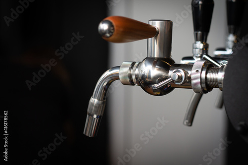Partially blurred silvery bar beer taps in pub