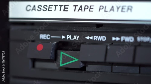 Play button being pressed by a male hand on a vintage retro cassette tape player. 4K photo