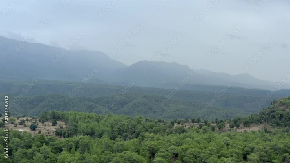 Drone video of a mountain landscape with forests with trees growing on mountain ranges and peaks and rain clouds above them. Aerial landscape view of Antalya Turkey. Drone video of a mountain landscape with forests with trees growing on mountain ranges and peaks and rain clouds above them. Aerial landscape view of Antalya Turkey.