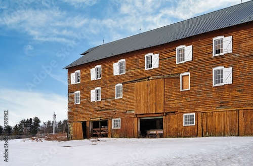 View of a brown wooden barn under snow after a winter storm in New Jersey