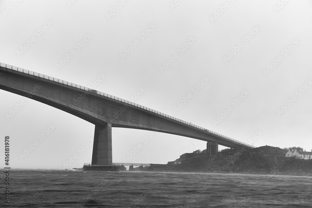 tall and long bridge on the isle of skye in scotland, uk. bench and black with copy space for advertising