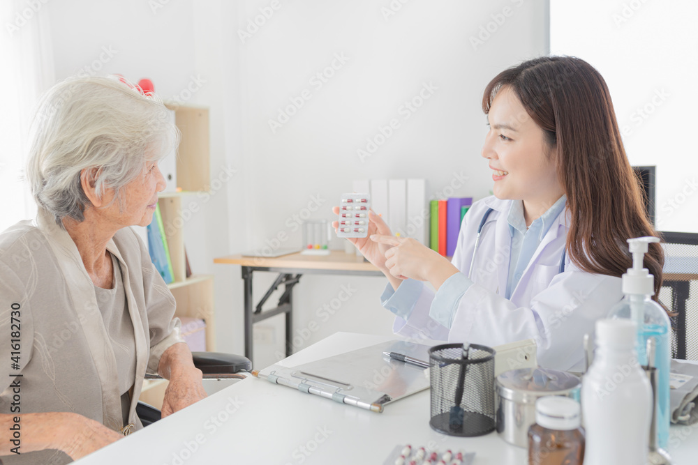 Obraz premium asian female doctor explaining about how to use medicine in hospital, elderly disease treatment, she holding drug strip pack with hand