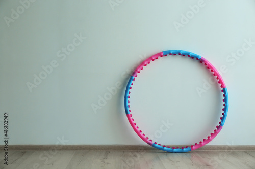Hula hoop near light wall in gym. Space for text
