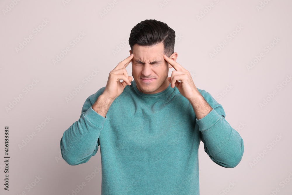 Portrait of stressed man on light background