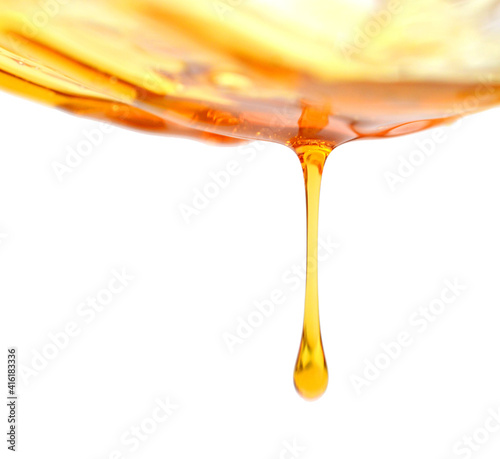 Sweet sticky honey puddle and honey drops isolated on white background. 