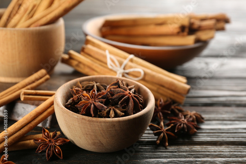 Fototapeta Naklejka Na Ścianę i Meble -  Aromatic cinnamon sticks and anise on wooden table, closeup
